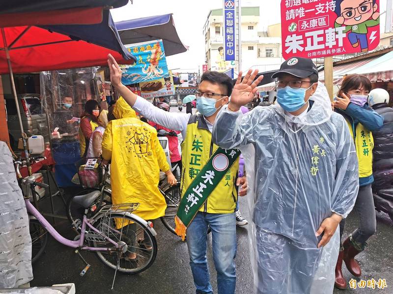 台南市長黃偉哲陪同參選永康區市議員的朱正軒，冒雨在傳統市場掃街、拜票，爭取鄉親支持。（記者吳俊鋒攝）