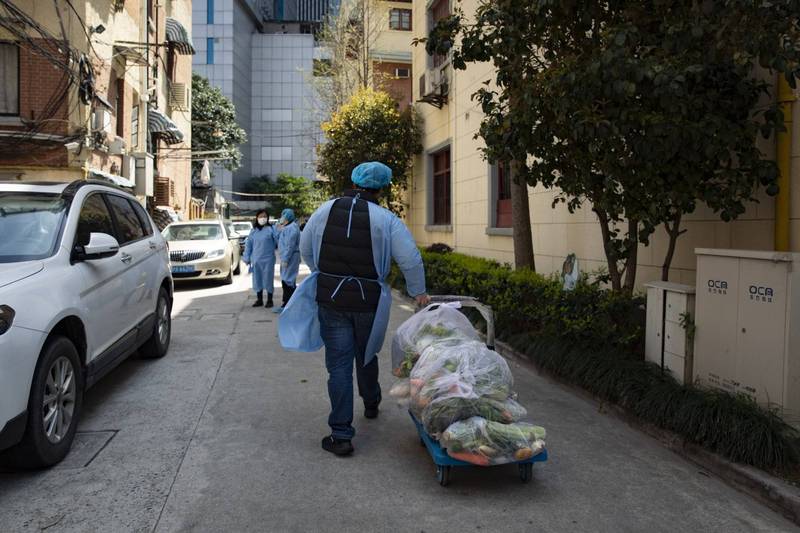 中國上海因應疫情封城，當地資深記者陳季冰撰文，直指上海的「全域靜態管理」是在「封城」下實施「計畫經濟」，而「計畫經濟」的狀態是防疫出現混亂的癥結。圖為上海志工沿街派發蔬菜包給無法出門的住戶。（彭博）