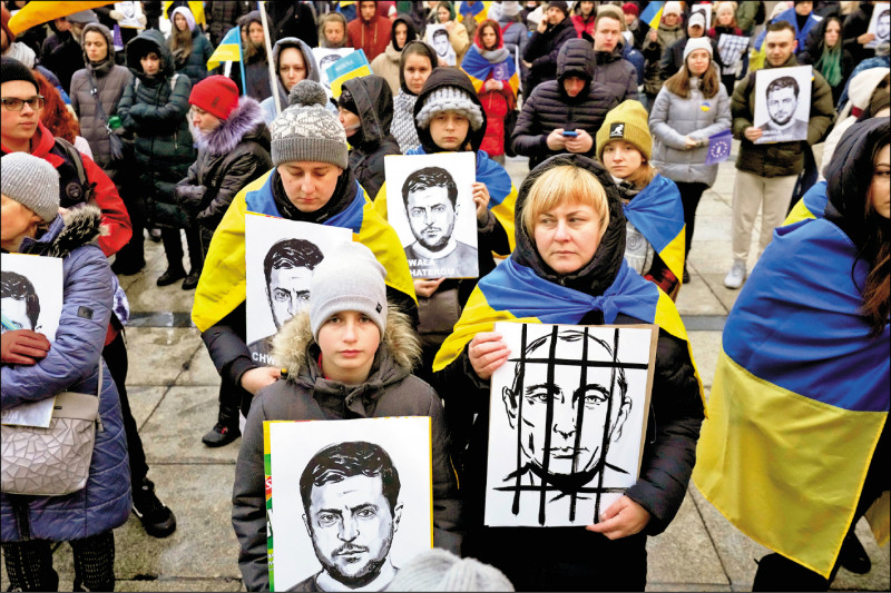 抗议人士2日手持乌克兰总统泽伦斯基与俄罗斯总统普廷的画像，参加波兰首都华沙科学文化宫前的反战示威。（美联社）(photo:LTN)