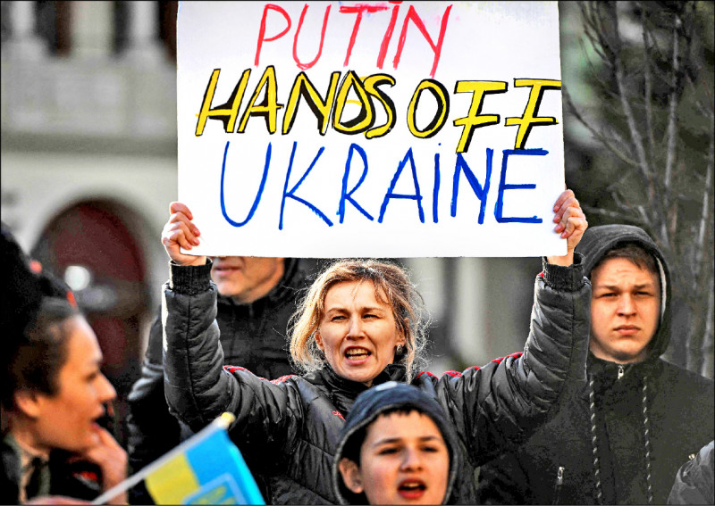 俄军在乌克兰首都基辅西北方小镇布查行刑式处决平民，震惊全球。图为民众举牌抗议俄罗斯入侵乌克兰。（法新社）(photo:LTN)