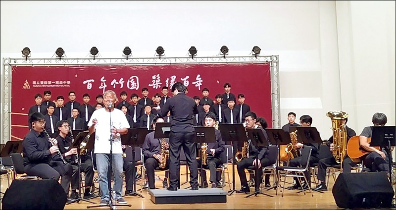 台南一中校友、金曲歌王謝銘祐（著白色上衣者），與學弟合作演出百年校慶主題曲〈南風〉。（南一中提供）