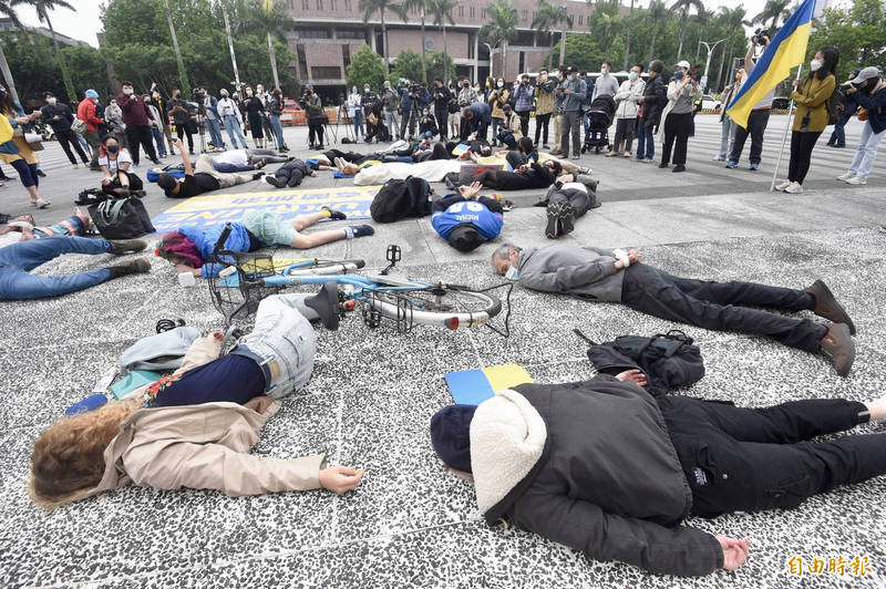 數十位在台烏克蘭學生及挺烏民眾，就俄羅斯對烏克蘭發動戰爭的種族滅絕惡行，在台北自由廣場前進行「假死抗議」活動。（記者叢昌瑾攝）