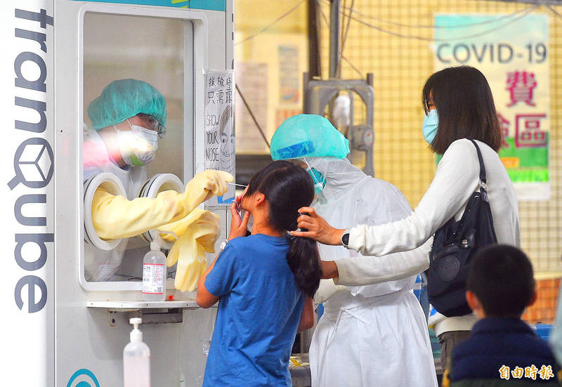 A mother takes her child to a COVID-19 testing station in Taipei yesterday.
Photo: Chang Chia-ming, Taipei Times
