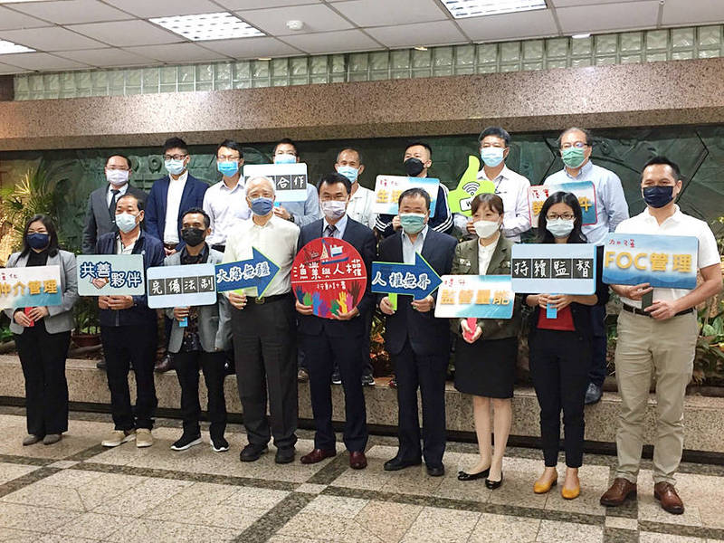 
Minister of Agriculture Chen Chi-chung, center front, and other officials hold signs at a news conference in Taipei yesterday to unveil the Fisheries and Human Rights Action Plan.
Photo: CNA