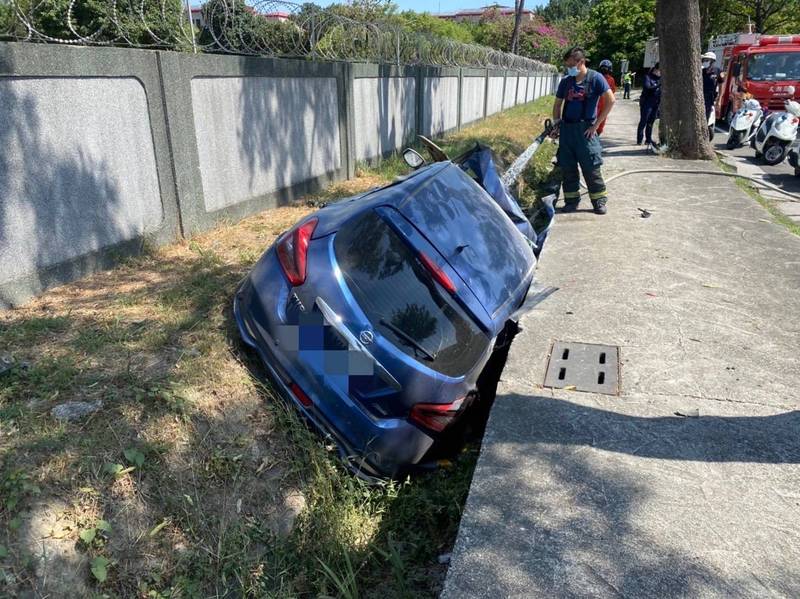 高雄余男開車衝入陸軍官校旁水溝，受困車內。（讀者提供）