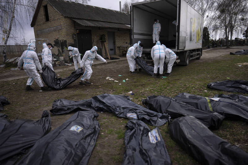 志工们正在搬运基辅近郊布查（Bucha）小镇上发现的遗体。（美联社）(photo:LTN)