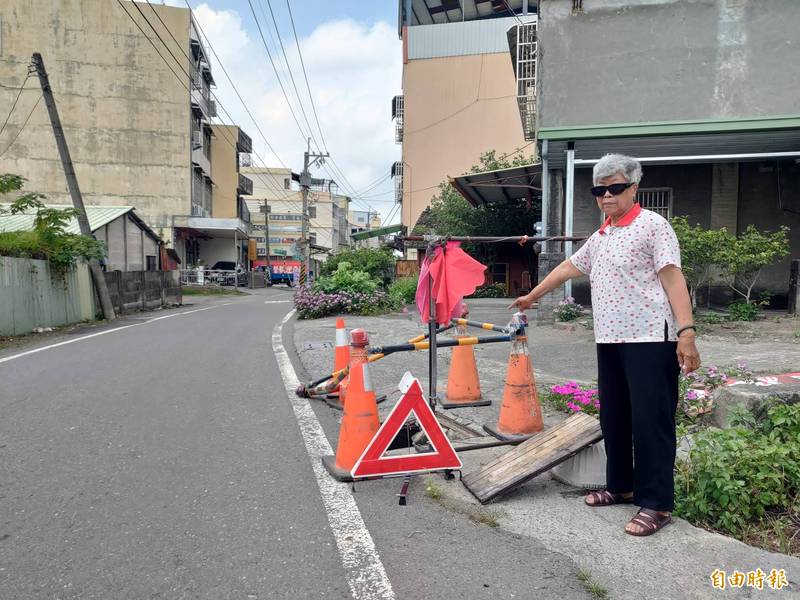 員林市大饒路破洞2個月，相關單位遲遲未派人修繕，當地民眾只好克難搬曬衣架跟三角板警示牌提醒用路人。（記者陳冠備攝）