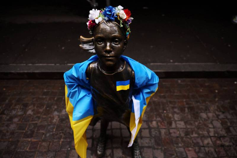 美國非營利團體「與烏克蘭同在」本月4日為著名雕像「無畏女孩」披上烏克蘭國旗。（路透）