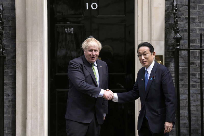 英國首相強生（左）會晤日本首相岸田文雄（右），強化兩國關係。（美聯社資料照）