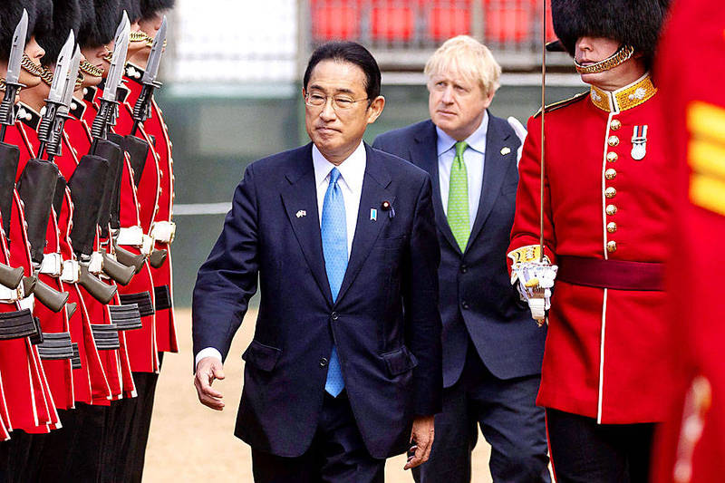 
Japanese Prime Minister Fumio Kishida front, and British Prime Minister Boris Johnson walk past honor guards at Westminster Hall in London on Thursday.
Photo: AFP