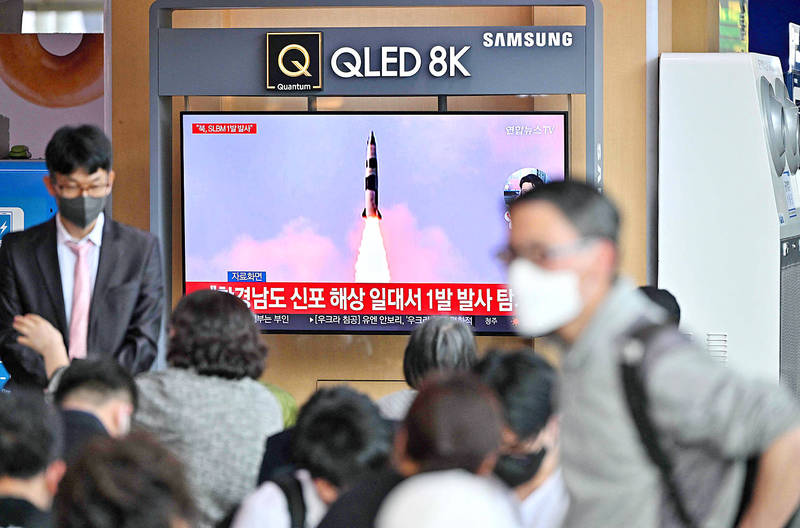 People watch a television screen showing a news broadcast with file footage of a North Korean missile test, at a railway station in Seoul yesterday.
Photo: AFP