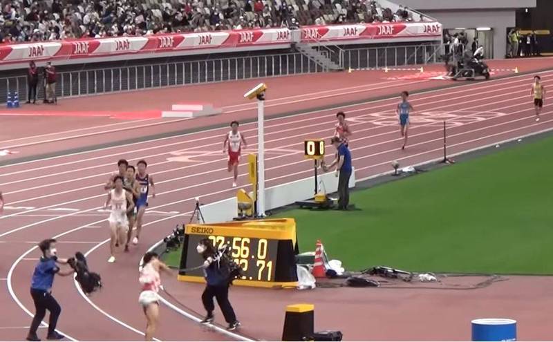 日本東京國立體育場7日晚間舉行1萬公尺錦標賽，但有日本放送協會（NHK）的攝影人員竟闖入跑道，電線更因此勒住剛好要通過的跑者。（圖擷自YouTube）
