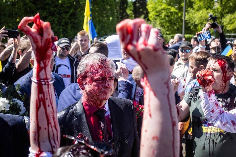 俄羅斯駐波蘭大使安德烈耶夫週一慘遭潑紅漆「洗臉」，民眾在一旁大聲叫好。（法新社）