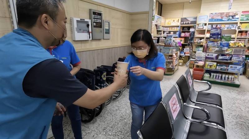 民進黨立法委員蔡適應服務處主任林明智（左）載著飲料，前往基隆醫療院所運送，向護理師致意。（圖由立法委員蔡適應服務處提供）