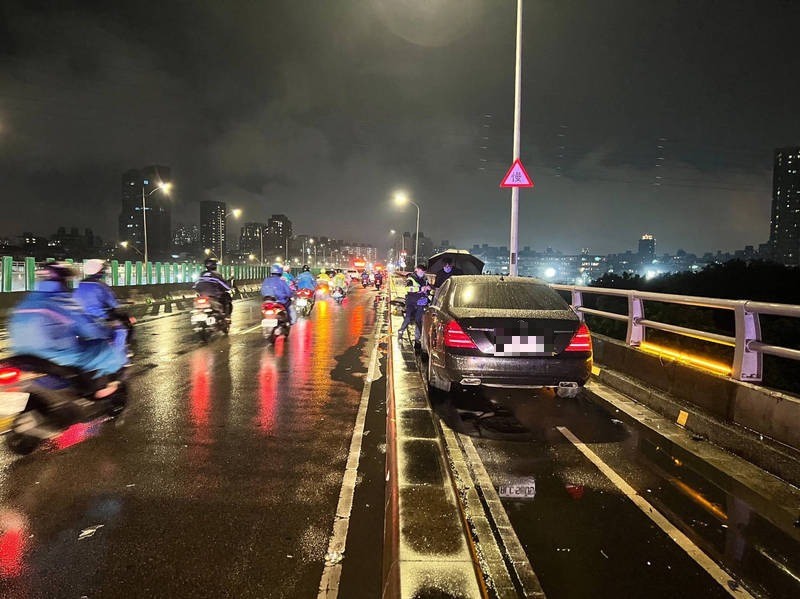 43歲張姓駕駛今晚開著黑色賓士轎車通過連接台北市與新北市的福和橋時，失控翻越機車道，連撞2機車，還卡在狹窄的機車道，造成車流受阻2小時。（記者闕敬倫翻攝）