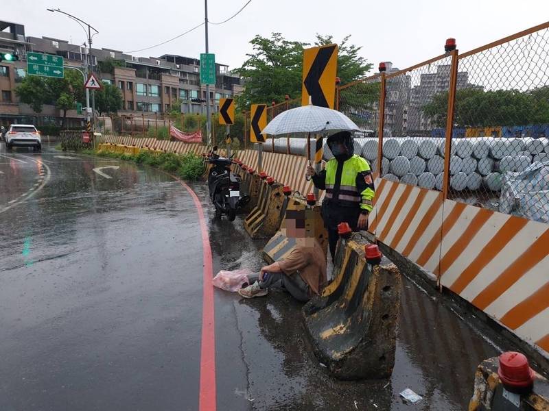 連天大雨路滑，騎機車易發生車禍，處理員警貼心協助撐傘。（民眾提供）