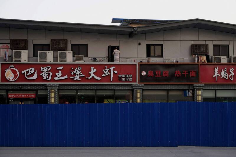 北京市内被围篱围起的住宅区，一位居民出现在2楼阳台上。（法新社）(photo:LTN)