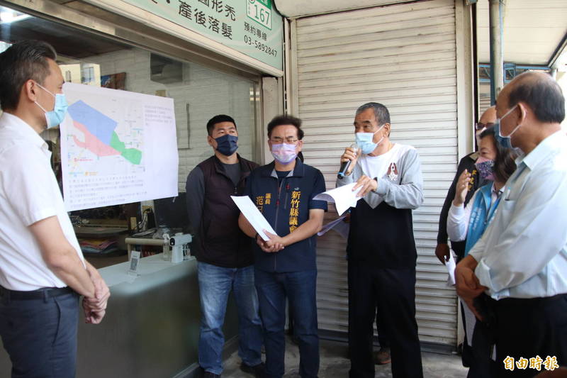 新埔鎮代會主席王增基（持麥克風者）嗆水公司3區處竹北營運所代表（左）不調回水壓，不排除抗爭。（記者黃美珠攝）