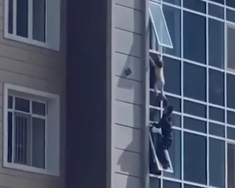 哈薩克有名3歲女童不幸受困在8樓窗外，被1名路過的男子驚險救下。（圖擷取自YouTube）