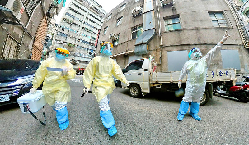 Health workers walk through a residential area in New Taipei City yesterday.
Photo courtesy of New Taipei City Social Welfare Department via CNA
