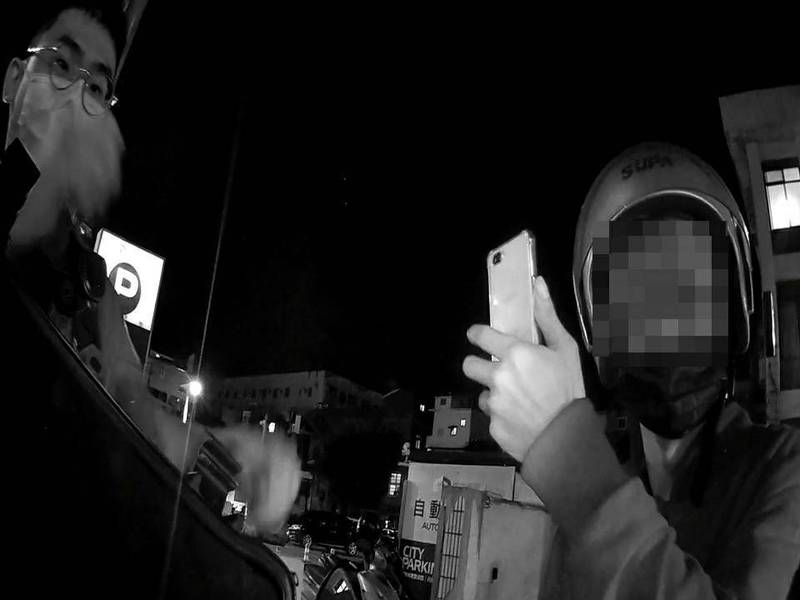 涉嫌酒後駕車的張姓男子（右）拿起手機拍攝並誣指警方不准他喝水。（警方提供）