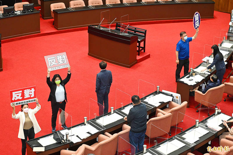 
Lawmakers signal their parties’ stances on the third reading of draft amendments to the National Security Act at the Legislative Yuan in Taipei yesterday.
Photo: Tien Yu-hua, Taipei Times