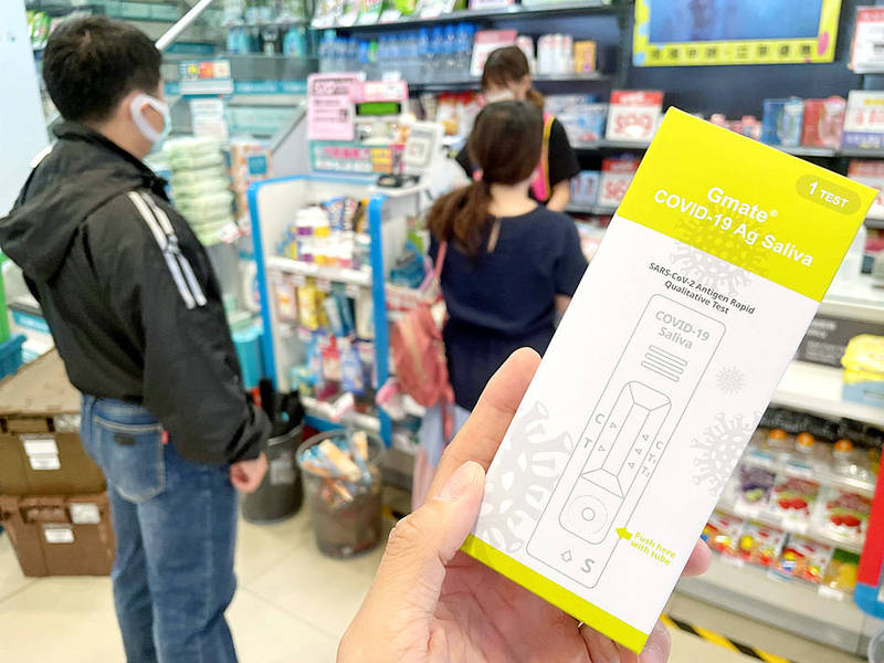 A customer holds a Gmate COVID-19 Ag Saliva rapid test kit in a Watson’s store in New Taipei City’s Lujhou District on Friday.
Photo: CNA