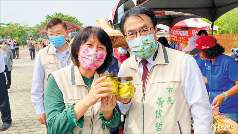 台南市長夫婦黃偉哲（右）和劉育菁（左）展示土芒果製成的情人果，酸甜好吃。（記者楊金城攝）