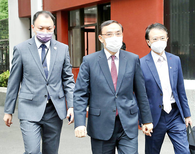 
Minister of Justice Tsai Ching-hsiang, center, walks to the legislature in Taipei yesterday to attend a meeting.
Photo: CNA