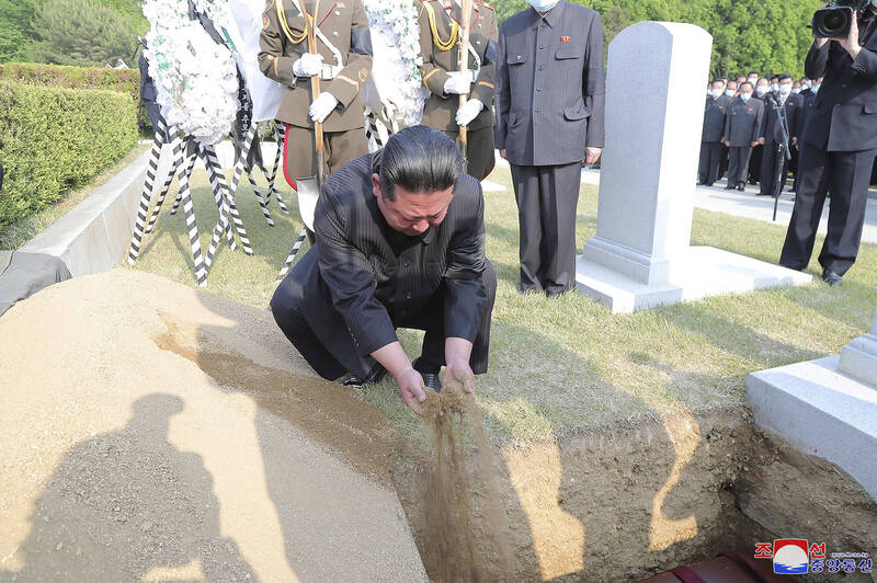 根据北韩官方的照片显示，金正恩在玄哲海的墓上洒了一把土。（美联社）(photo:LTN)