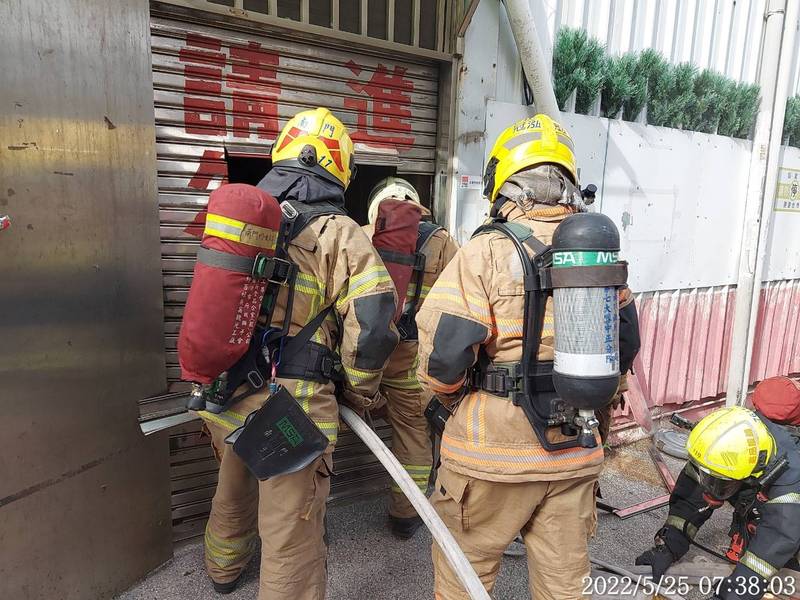消防人員破壞書局鐵門進入灌救。（南市消防局提供）