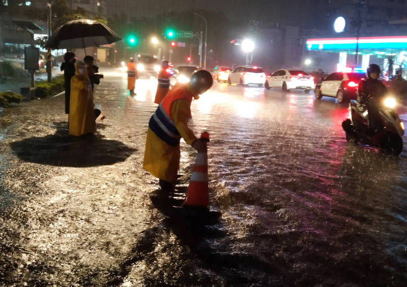 中壢區崁頂路昨晚一度淹水達到3、40公分，消防局派員到場量測水位。（記者李容萍翻攝）