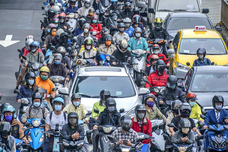Motorists and vehicles wait at a traffic light in Taipei on Tuesday.
Photo: Bloomberg