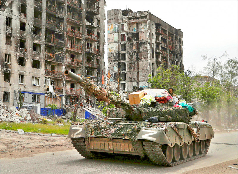 亲俄武装部队的坦克26日行驶在乌东波帕斯纳（Popasna）街头，一旁是被炸毁的住宅建筑。（路透）(photo:LTN)