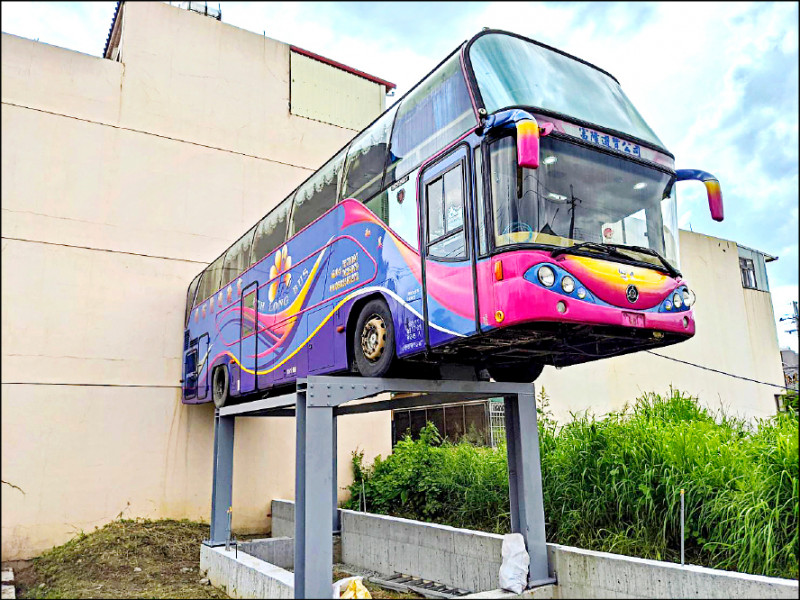 南投縣竹山鎮市區住宅區，近來出現一輛「飛天」遊覽車，架在空地三公尺高平台上，因緊鄰透天厝，遠看有如「飛天穿牆過」。設計者是冷氣裝修師黃建平，因造訪過遊覽車主題露營區，加上想打造親友聚會所，才購入報廢遊覽車自行加裝衛浴、流理台，要逐步完成「類樹屋」秘密基地，雖然還未完工，但醒目的飛天車，已吸引不少民眾打卡拍照。（圖文：記者劉濱銓）