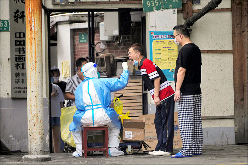 即将从六月一日起「解封」的上海市某地，居民卅日排队接受被称为「大白」的防疫工作人员採检。（路透）(photo:LTN)