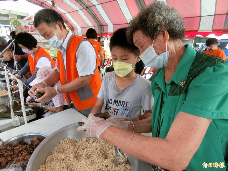 弘道老人福利基金會嘉義服務處今天在嘉義縣東石鄉港墘社區舉辦「耆包粽慶端午」活動，長輩們開心包粽。（記者林宜樟攝）