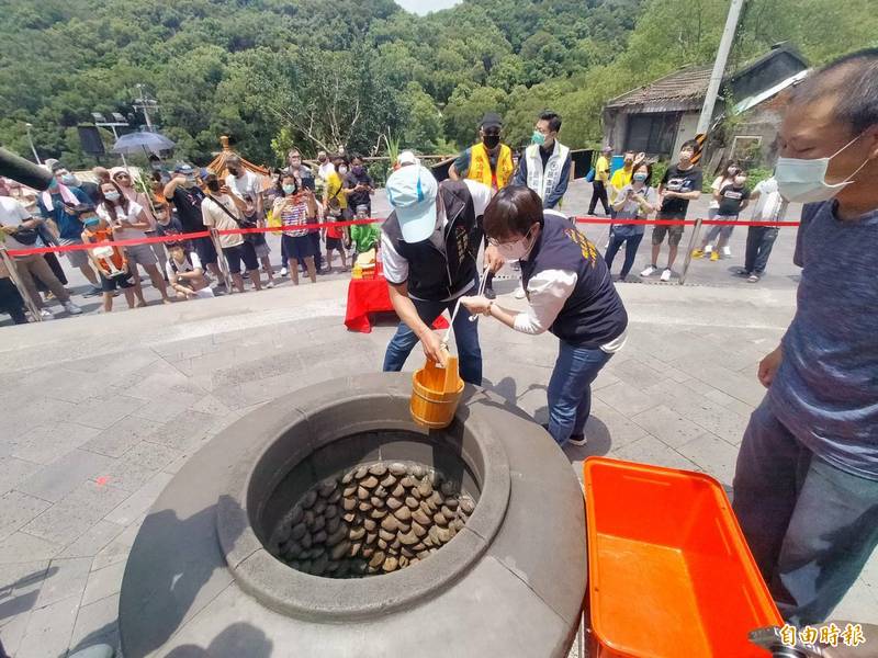 台中市觀旅局長韓育琪（右）取劍井午時水。（記者張軒哲攝）