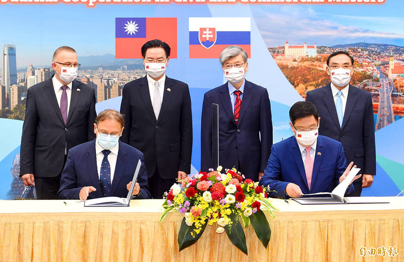 Slovak Representative to Taiwan Martin Podstavek, front left, and Representative to Slovakia David Lee, front right, sign an agreement witnessed by, back from left, Slovak National Council Deputy Speaker Milan Laurencik, Minister of Foreign Affairs Joseph Wu, Judicial Yuan Vice President Tsai Chung-tun and Minister of Justice Tsai Tsing-hsiang at the Ministry of Foreign Affairs in Taipei yesterday.
Photo: Liu Hsin-de, Taipei Times