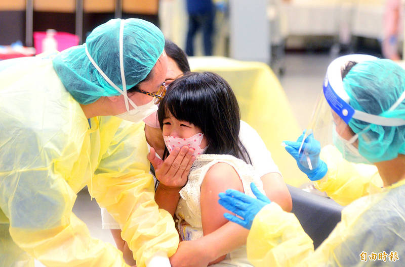 A woman holds her daughter as she receives a COVID-19 vaccine at a vaccination station in Taipei on June 1.
Photo: Wang Yi-sung, Taipei Times