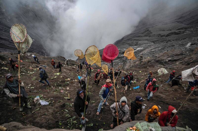 非腾格尔族的村民站在火山口的陡坡上试图拦截祭品。（法新社）(photo:LTN)