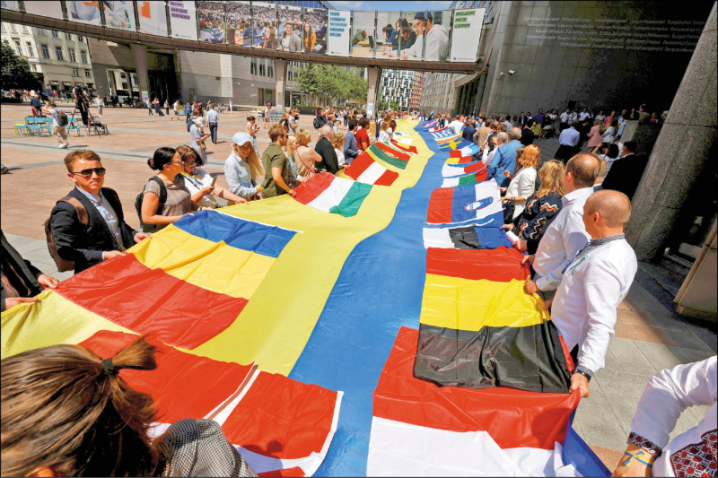 欧洲议会议员23日在布鲁塞尔展开一幅长达30公尺的乌克兰国旗，展现对基辅的支持。（路透）(photo:LTN)