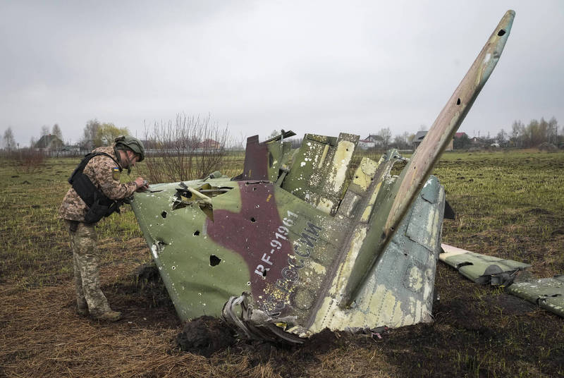 英国最新情报指出，俄罗斯军队在乌克兰战争中失血惨重，没有足够训练有素的飞行员，俄军被迫派遣担任佣兵的退伍军人飞行员上阵。图为乌克兰军人在4月间检视一架被击落的苏恺-25战机残骸。（美联社）(photo:LTN)