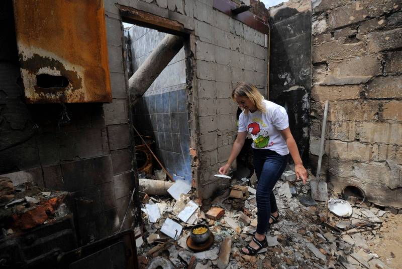 切爾尼戈夫地區已遭俄軍多次轟炸，當地一名村民在她的破屋中料理下一餐。（法新社）