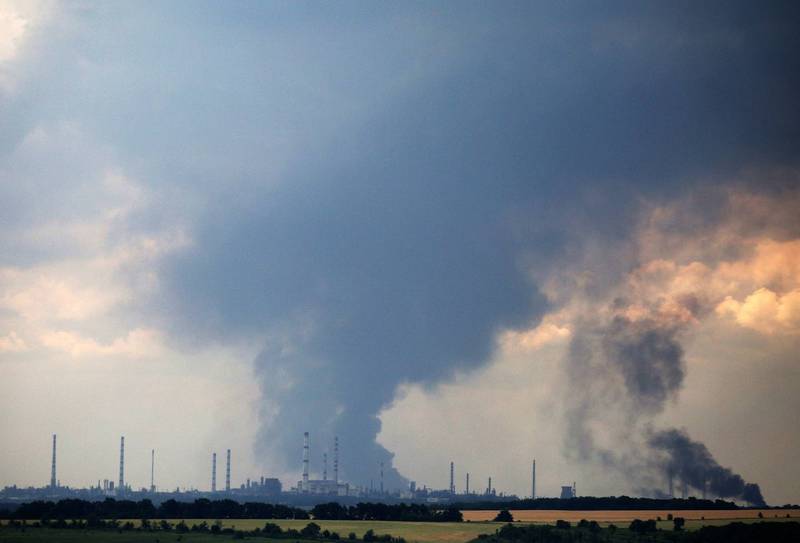 利西昌斯克外围的炼油厂正冒出浓烟。由于俄军逼近利西昌斯克市，《法新社》的战地记者被迫撤离，他们在驾车途中拍下了这张照片。（法新社）(photo:LTN)