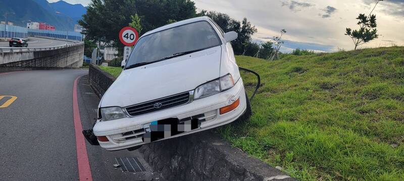 花蓮一輛白色自小客車，沿華西路南向北行駛，欲左轉七星潭大橋，疑因車速過快失控，直接衝入曼波園區內卡在邊坡上。（圖由警方提供）