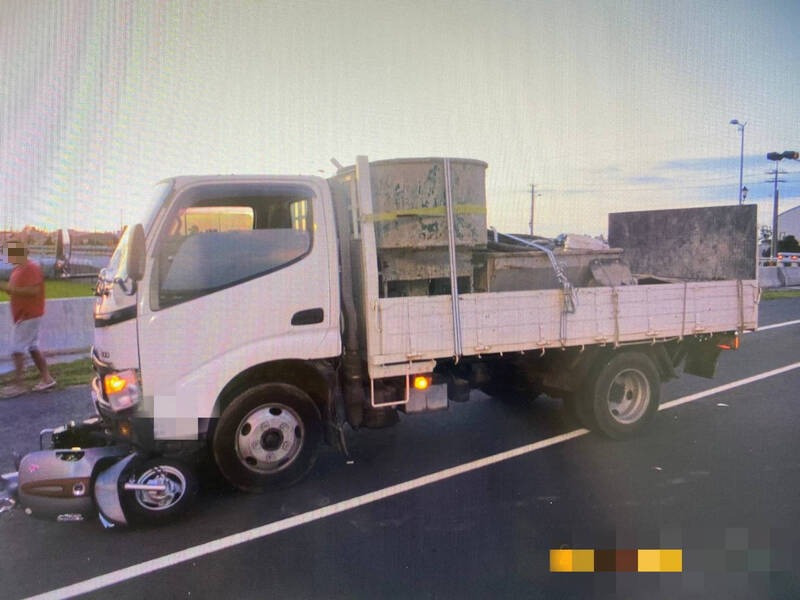 貨車在台中龍井疑闖紅燈與女騎士發生碰撞，機車卡在車頭下。（警方提供）