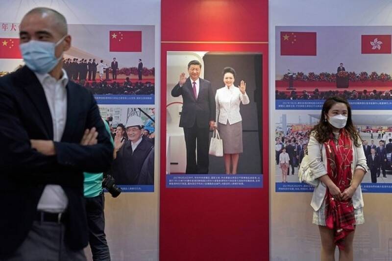 香港舉行慶祝「回歸」中國25週年展覽上，參觀者站在一張中國國家主席習近平和夫人彭麗媛在香港的照片前。（美聯社）