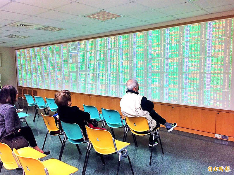 People look at an electronic stock board at a securities firm in Taipei yesterday.
Photo: Kelson Wang, Taipei Times