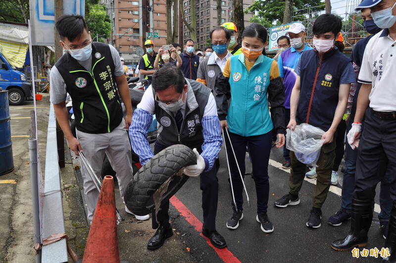桃園市長鄭文燦（左2）動手倒乾路旁輪胎內的積水，宣導登革熱防治工作。（記者周敏鴻攝）